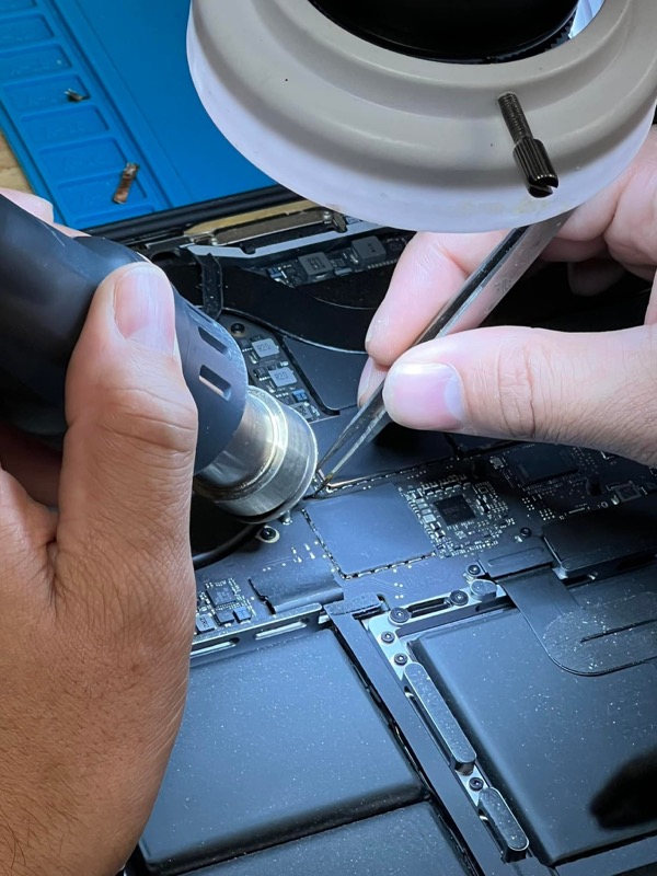 Close-up of IC chip replacement on a MacBook logic board at The Mac Space