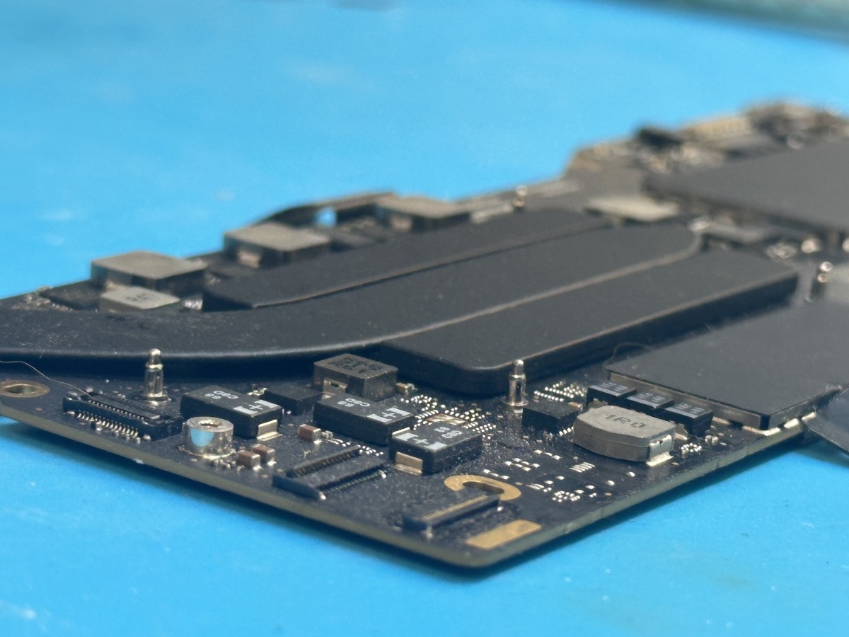 Close-up of MacBook logic board under repair at The Mac Space in Marietta GA