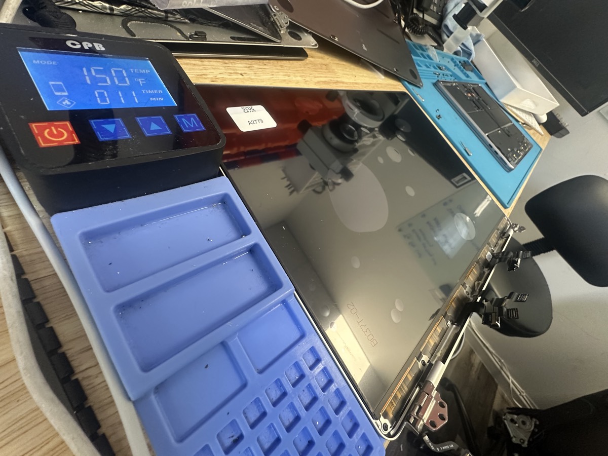 MacBook Pro display replacement process showing new screen being installed at The Mac Space