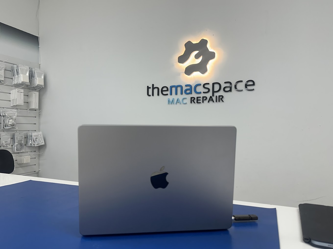 The Mac Space repair counter with backlit wrench logo and MacBook - professional Mac repair service in Marietta GA